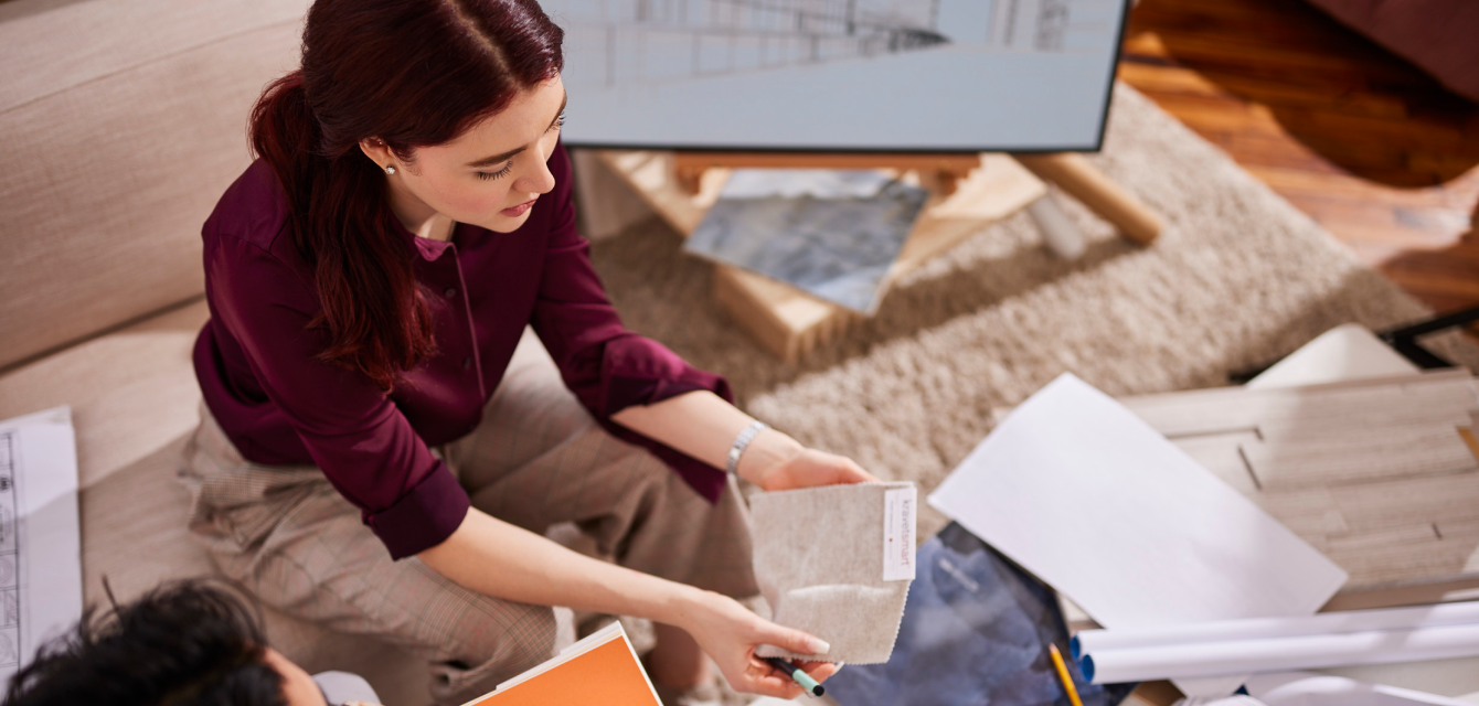 Woman sitting at a table with design files in front of her